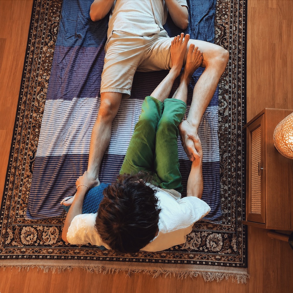 Traditional Thai massage stretch performed on a mat